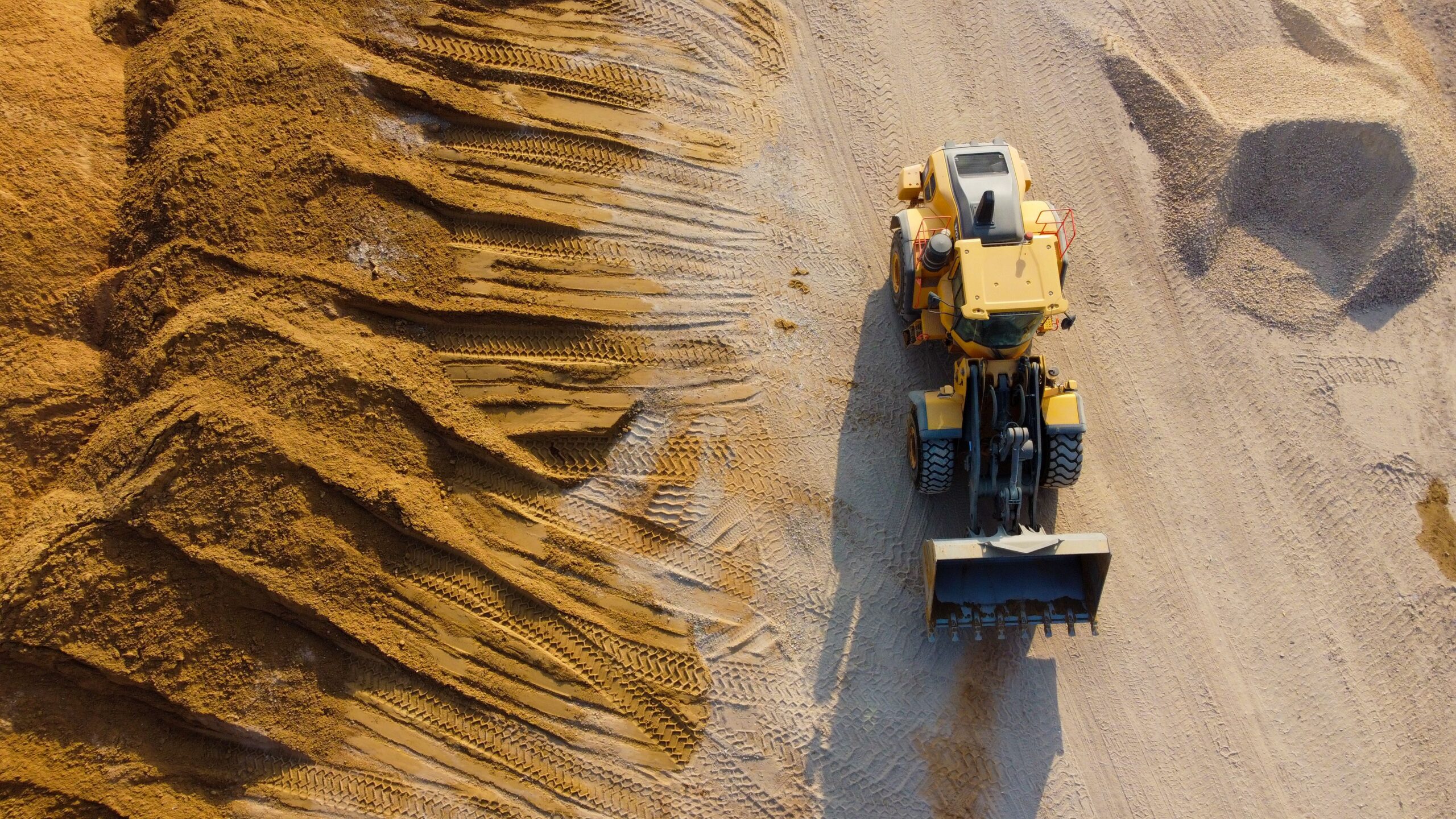 Heavy crawler excavator performing precision earthworks utilizing MGB TECH GNSS receivers and real time machine guidance hardware
